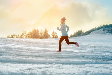 Running woman. Runner on the snow in winter sunny day. Female fi