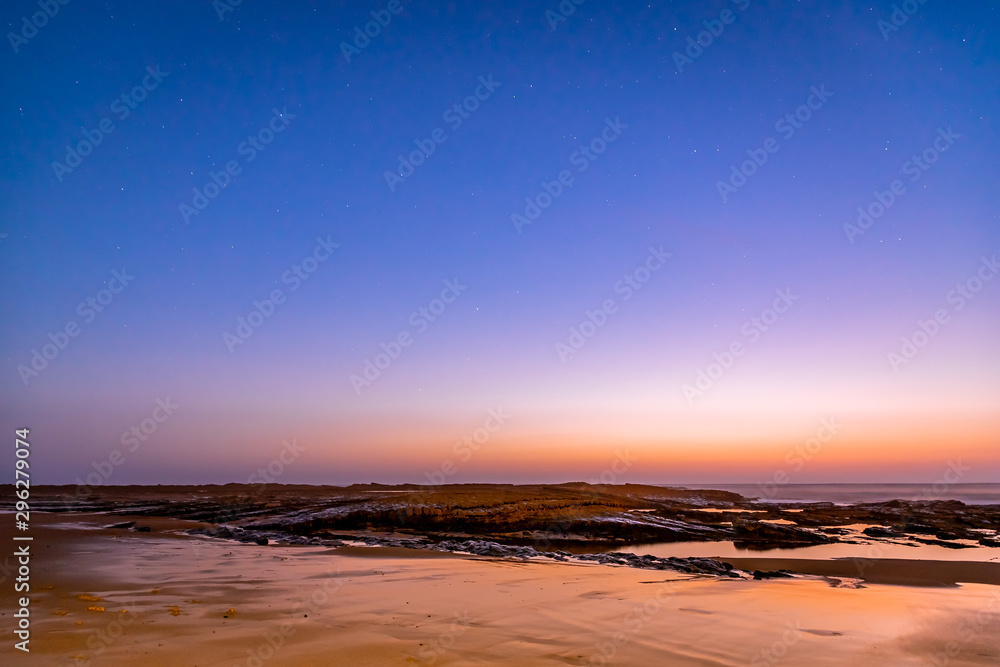 Sunset in Algarve under clear starry skies