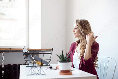 Calm happy businesswoman relaxes in workplace during a break. Smiling woman stretching on work chair, enjoys at work © Viktoria