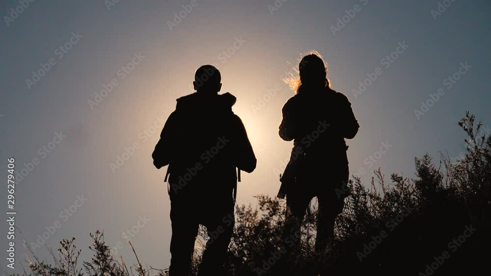 teamwork tourists travel concept slow motion video. hiking silhouette happy family couple man and girl go hiking climbing a mountain. lifestyle walking on nature. tourists with backpacks traveling teamwork tourists travel concept slow motion video. hiking silhouette happy family couple man and girl go hiking climbing a mountain. lifestyle walking on nature. tourists with backpacks traveling