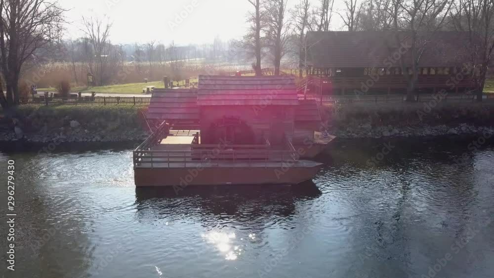 Aerial: Flying over river water mill at bank of beautiful green river. Filming beautiful river surroundings at spring sunset. Aerial: Flying over river water mill at bank of beautiful green river. Filming beautiful river surroundings at spring sunset.