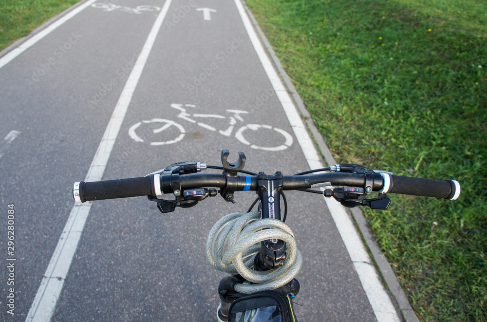 Bicycle handlebar on a bike path with markings in the park.