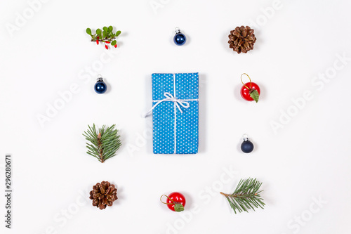 Creative flat lay of wrapped with bow gift in blue craft paper on white background. Flat lay, top view. Holidays collection and christmas concept.