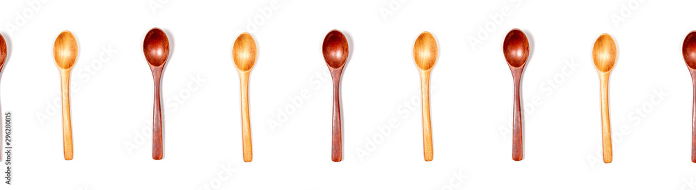 Top view of handmade wooden empty spoons isolated on white background. Banner format. Bright and dark wood. Street food and zero waste concept. Top view of handmade wooden empty spoons isolated on white background. Banner format. Bright and dark wood. Street food and zero waste concept.
