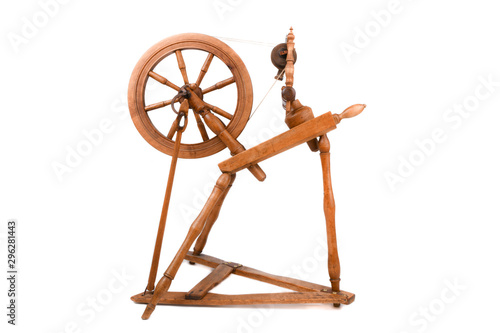 Old wooden yarn spinning wheel isolated on a white background. Very old wheel and spokes of a hand crafted spinning wheel made from natural wood. Historical working tool. Isolated on white background.