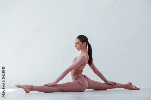 Years of training. Caucasian pretty woman doing exercises against white background in the studio