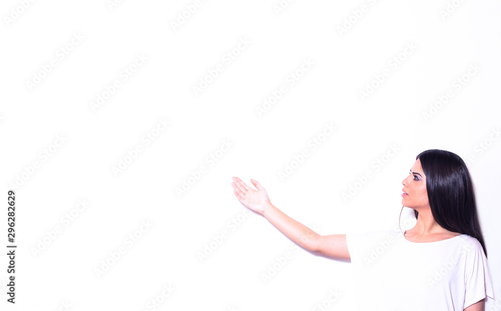 Portrait of a beautiful young woman presenting on one side with the palm of her hand on blank white background. Copy space.
