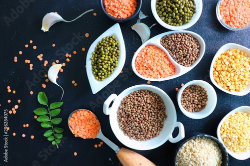 Composition of dry legumes. Assortment of colorful legumes in bowls. Lentils  Moth beans  Mung Beans  Masoor or red lentils  Split Chickpea  Toor Dal  Raw Split Mung Bean Lentils  Yellow Split.