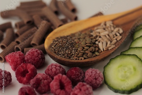 Sample foods from low-GI PCOS (Polycystic Ovary Syndrome) diet. Lentils, chia seeds, sunflower seeds, buckwheat pasta, raspberries and cucumber.  photo