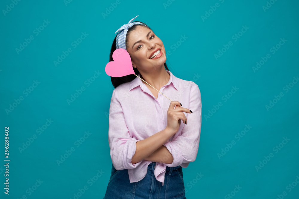 Fototapeta premium Brunette in white shirt and jeans keeping paper heart