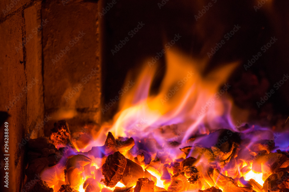 Bright fire burns on coals close-up. Carbon dioxide flies out with a blue spark. Bright fire burns on coals close-up. Carbon dioxide flies out with a blue spark.