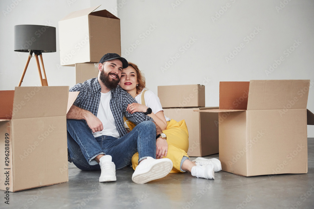 Let's rest for a moment. Happy couple together in their new house. Conception of moving Let's rest for a moment. Happy couple together in their new house. Conception of moving