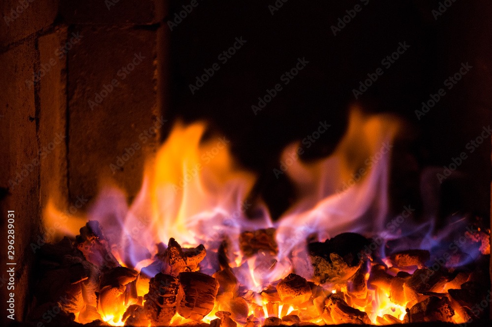 Bright fire burns on coals close-up. Carbon dioxide flies out with a blue spark. Bright fire burns on coals close-up. Carbon dioxide flies out with a blue spark.