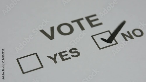 black ink pen put a tick check mark sign in check box on white paper. for vote no. closed up and selective focus