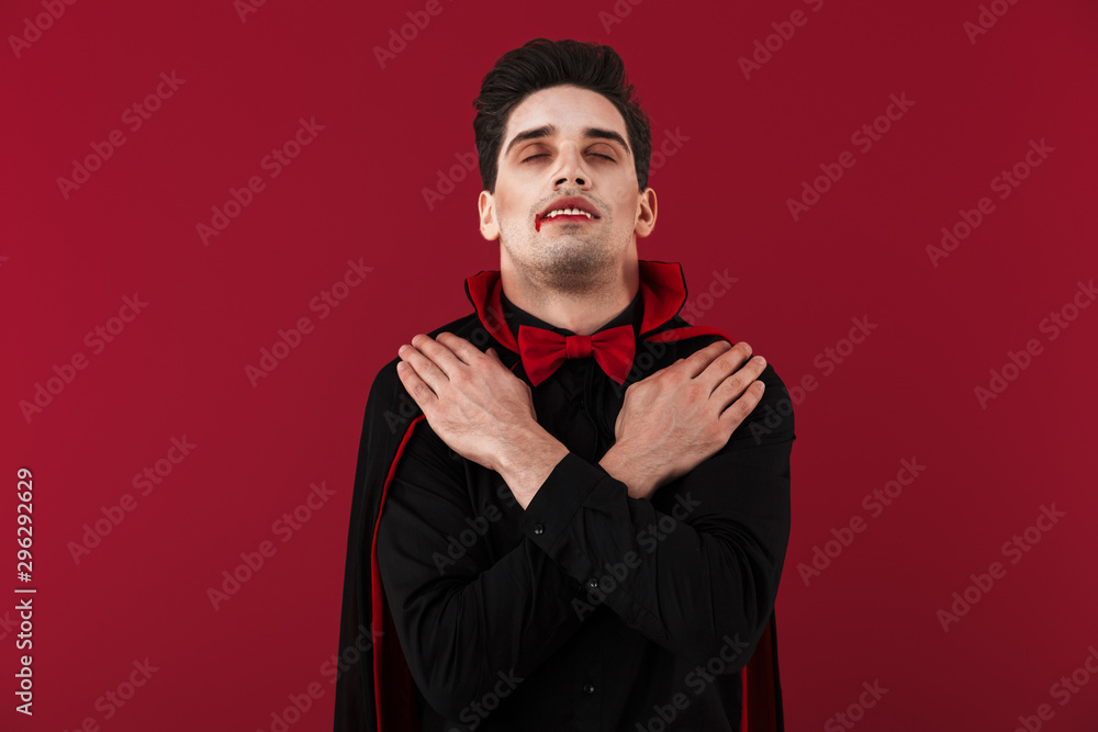 Image of vampire man with fangs in black halloween sleeping as dead Image of vampire man with fangs in black halloween sleeping as dead