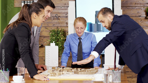 Businessman in suit in the conference room talking with team of architects