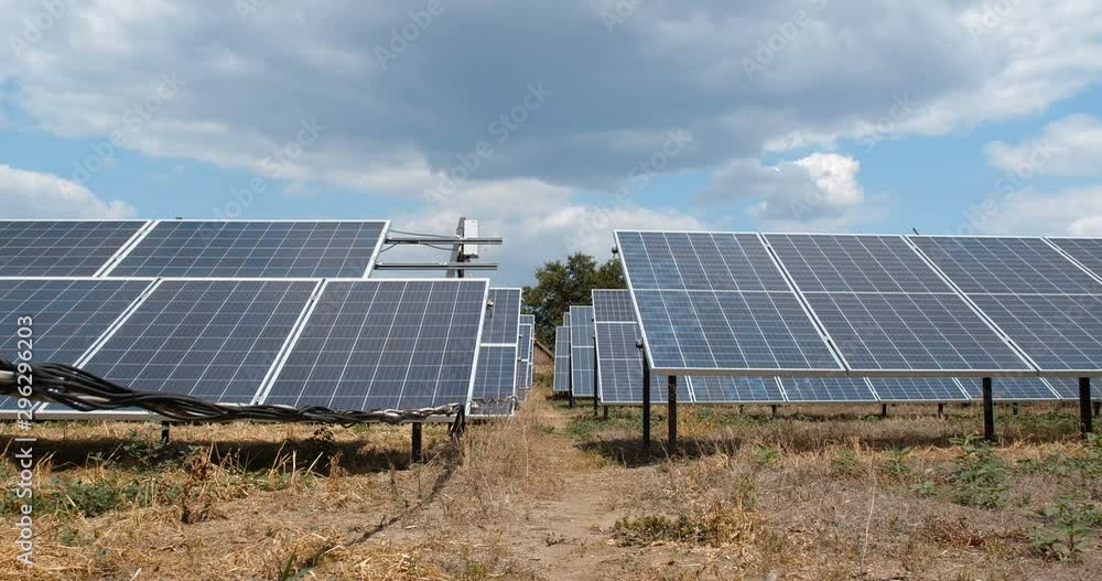 Low angle view dolly slide camera shot of the panels of small solar power plant mounted on the ground. Alternative energy sources. Ecological production of electricity without environment pollution Low angle view dolly slide camera shot of the panels of small solar power plant mounted on the ground. Alternative energy sources. Ecological production of electricity without environment pollution