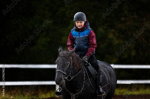 A little boy riding a horse safely