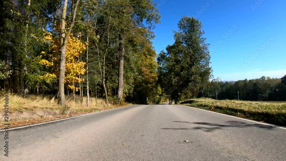 Autumn car drive in rural landscape. Car drive in fall landscape with fall colored trees and blue sky in sunny day. Countryside road. Fall concept Autumn car drive in rural landscape. Car drive in fall landscape with fall colored trees and blue sky in sunny day. Countryside road. Fall concept