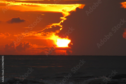 beautiful red sunset over the ocean. Bright sunset with large yellow sun under the sea surface. sundown seascape