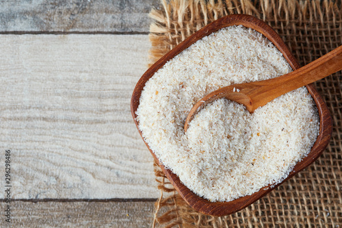 Psyllium (ispaghula) husk in wooden bowl on rustic background. Top view with copy space