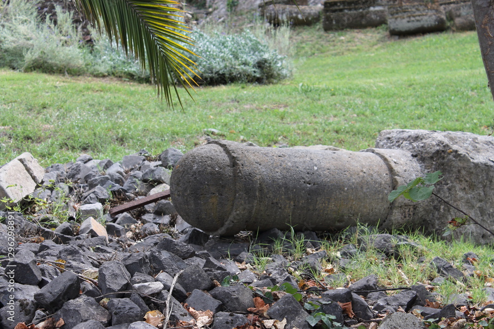 A fragment of an old column lies on the grass A fragment of an old column lies on the grass