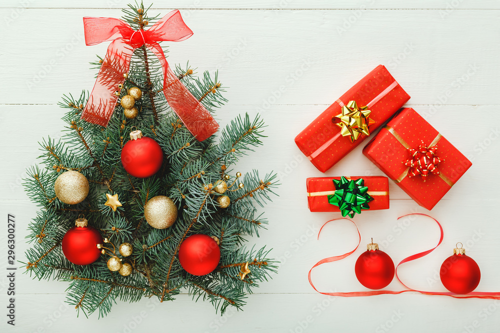 Φωτογραφία Xmas New Year pattern composition: Christmas Tree made from fir branches, red gift boxes on white wooden background, concept of holiday celebration 2020 lettering