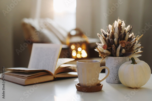 Autumn still life. Coffee cup, flowers, book and pumpkin. Hygge lifestyle, cozy autumn mood. Flat lay, Happy thanksgiving 