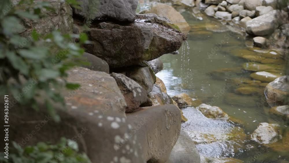 Streams of pure mountain water flow over the stones of the waterfall Streams of pure mountain water flow over the stones of the waterfall