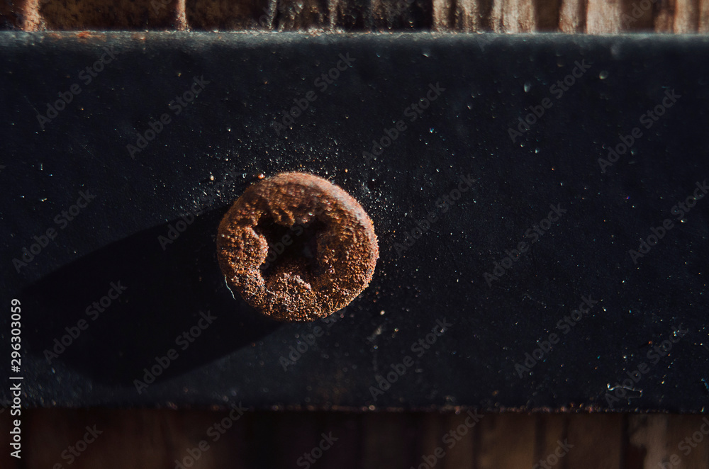 Closeup of an old rusty screw on a wooden flower pot. Selective focus. Closeup of an old rusty screw on a wooden flower pot. Selective focus.