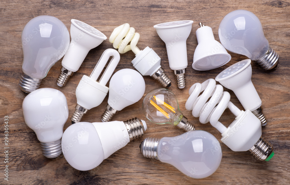 Different kinds of light bulbs on wooden background - obrazy, fototapety, plakaty 