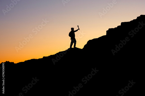 the photo on the sunset sky and mountain is visible in silhouette