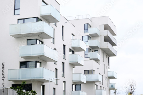 Exterior of a modern apartment buildings with balcony and white walls.