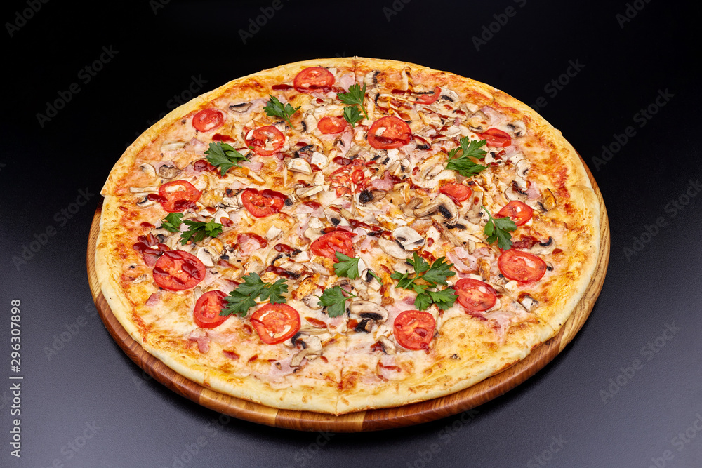 Fresh pizza with BBQ sauce on wooden cutting board. isolated on dark background.