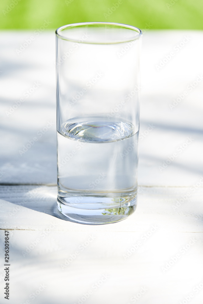 fresh clean water in transparent glass at sunny day on wooden table fresh clean water in transparent glass at sunny day on wooden table