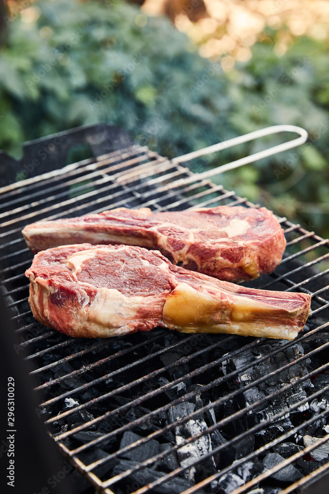 raw meat grilling on barbecue grid and coal pieces outside raw meat grilling on barbecue grid and coal pieces outside