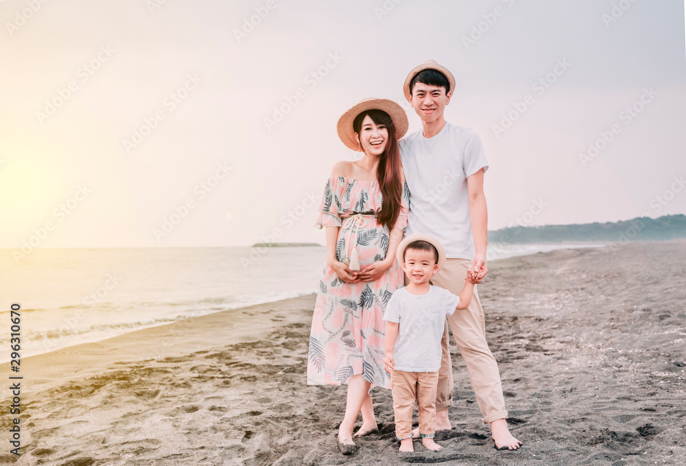 happy asian family standing on the beach at sunset happy asian family standing on the beach at sunset