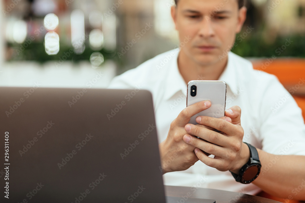 Man using a laptop and smartphone in coffee shop Man using a laptop and smartphone in coffee shop