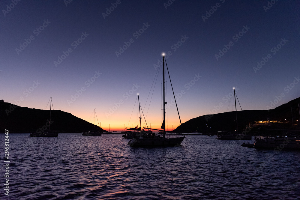 siling yachts in front of a sunset