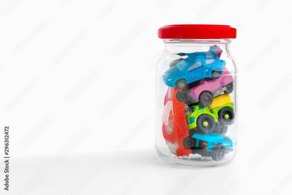 Toy cars in glass bottle. Unusable cars, automobiles. Traffic Jam in transparent jar on white background. Traffic jams on the road. Conceptual Toy cars in glass bottle. Unusable cars, automobiles. Traffic Jam in transparent jar on white background. Traffic jams on the road. Conceptual