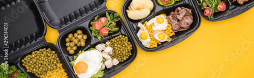 panoramic shot of eco packages with apples, vegetables, meat, fried eggs and salads isolated on yellow