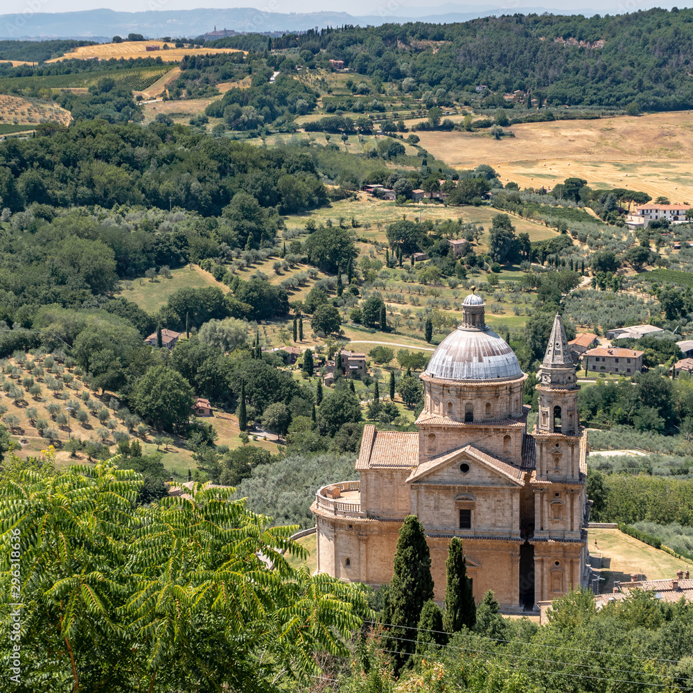 A church In Montalcino Tuscany With Trees, Vineyards, Crops And Hills in the Background