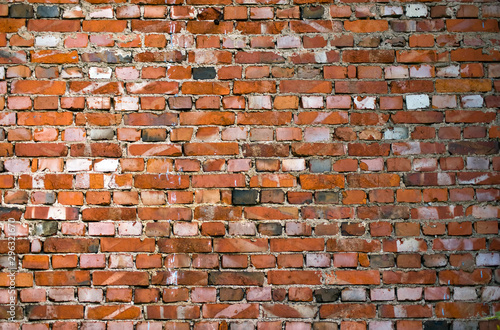 Old brick wall. Multi-colored brickwork with wide concrete seams in the loft style.