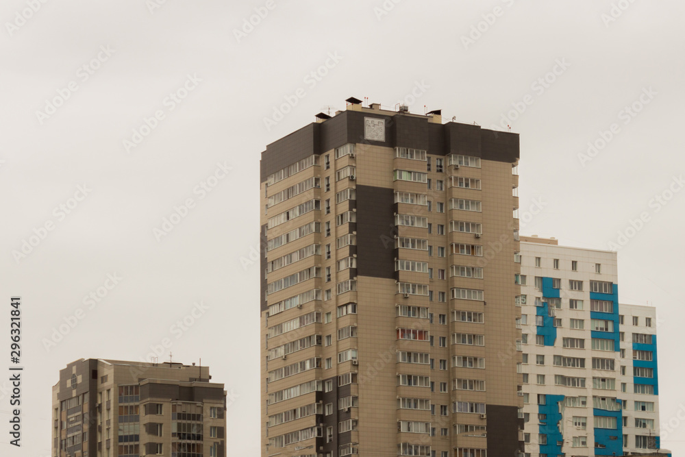 Three high-rise apartment buildings against the gray sky. Sad look.