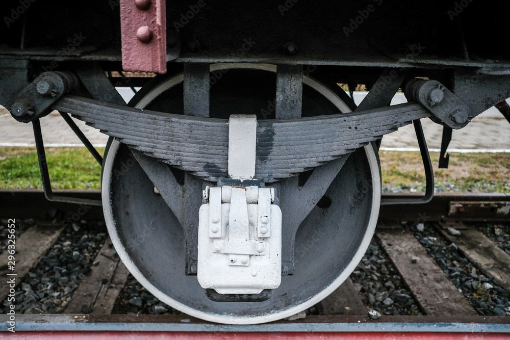 Black wheels of an old Russian locomotive on the rails close-up.