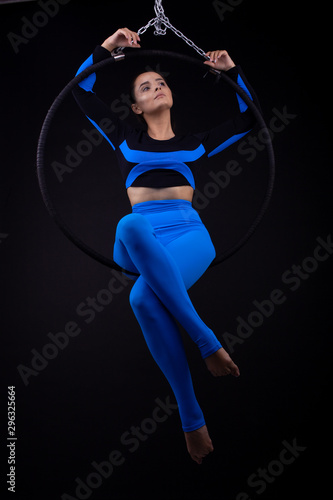 A female gymnast performing exercises on an air ring (hoop) © Oleksii
