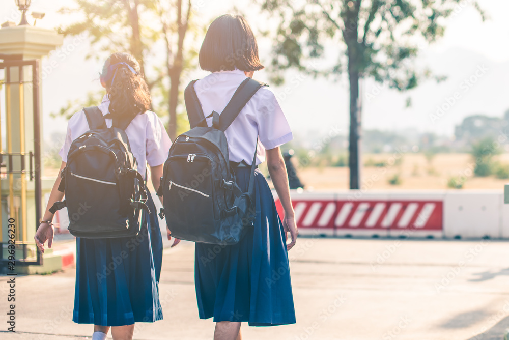 Asian female high school students in white uniform are going back home after school.