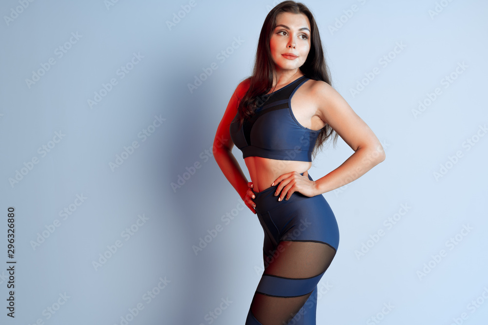 Healthy fit young woman in sportswear standing over a gray background Healthy fit young woman in sportswear standing over a gray background