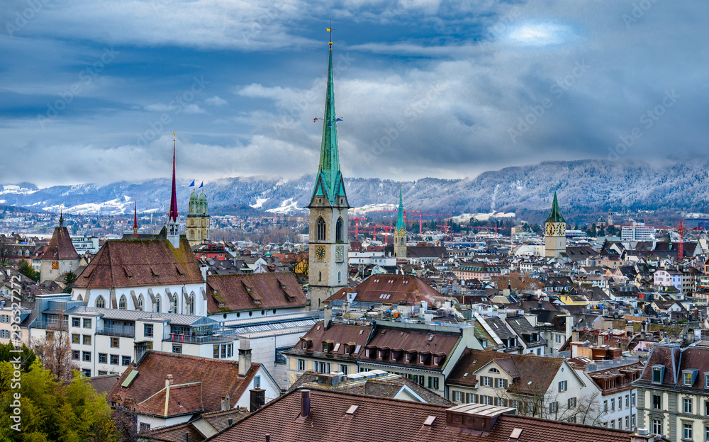 Scenery of old town of Zurich over snow covered Alps from University hill.