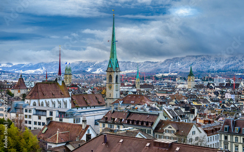 Scenery of old town of Zurich over snow covered Alps from University hill.